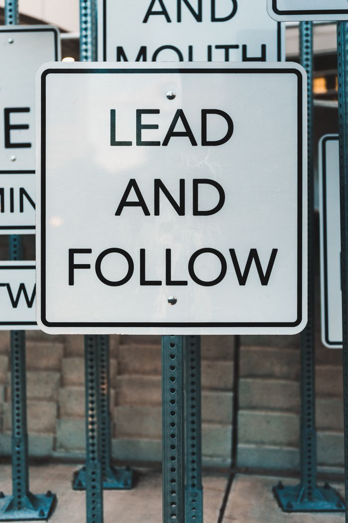gallery-01 Photo of urban signage displaying Lead and Follow, emphasizing guidance and navigation.